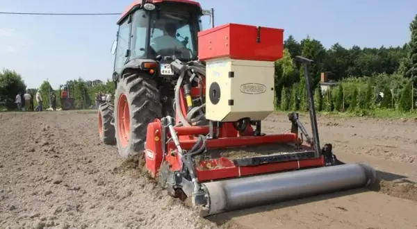 Ciągnik z siewnikiem Forigo basamid przygotowuje pole do siewu. Maszyna równa i wałuje ziemię.