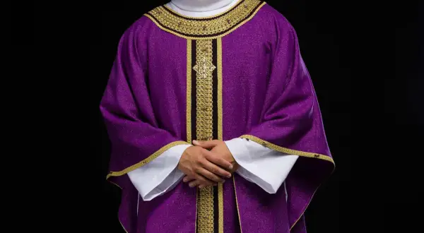 Fioletowa szata liturgiczna z bogatymi złotymi zdobieniami, symbolizująca czas pokuty i oczekiwania.