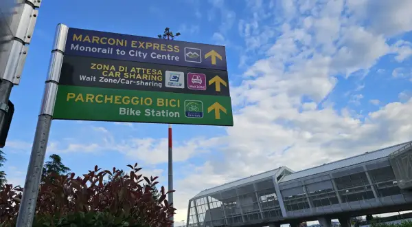 Znaki kierunkowe na lotnisku Bolonia: Marconi Express, Car Sharing i Bike Station.