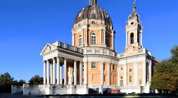 Basilica di Superga, maestosa con la sua cupola imponente, domina il panorama di Torino. Un gioiello architettonico sotto un cielo azzurro.