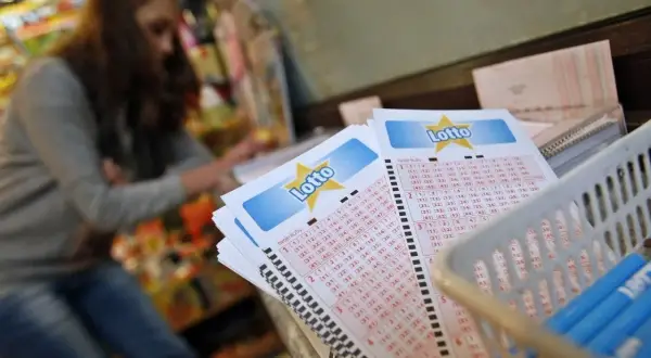 Kobieta wybiera liczby na kuponach Lotto. Czy prawda o rzekomym "ciepłym druku" który ma ułatwiać wygrywanie jest w zasięgu ręki?