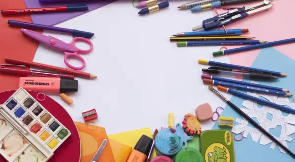 Bunt und ordentlich: Buntstifte, Scheren, Wasserfarben und mehr liegen bereit, um Schulsachen zu organisieren.