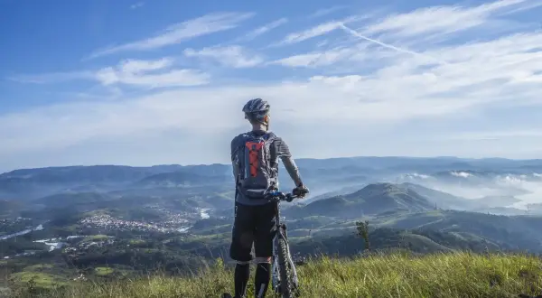 Rowerzysta na szczycie górskiego krajobrazu, podziwiający widok. Przygoda w Beskidach na rowerze.