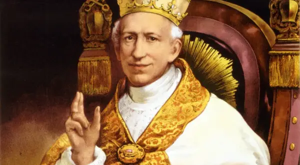 Portret papieża Leona XIII w bogatych szatach i tiarze, błogosławiący gestem dłoni.