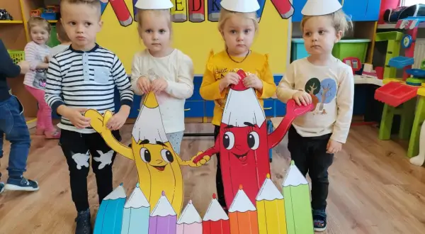 Dzieci w czapkach urodzinowych świętują dzień kredki. Pomysły na kreatywne zabawy z kolorowymi kredkami.