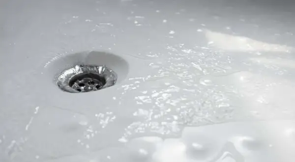 Acqua che scorre nello scarico della doccia, un segno che la pulizia è stata efficace.