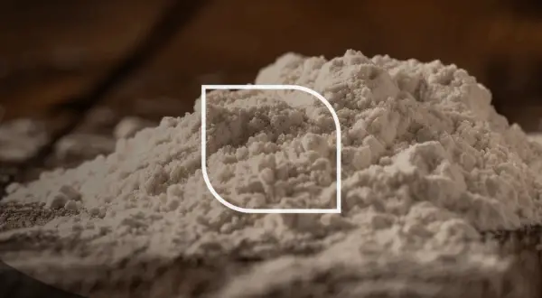 Stos białego proszku, być może mąki, z widocznym logo foodcom.pl. Ten ci 77891 jest idealny do wypieków.