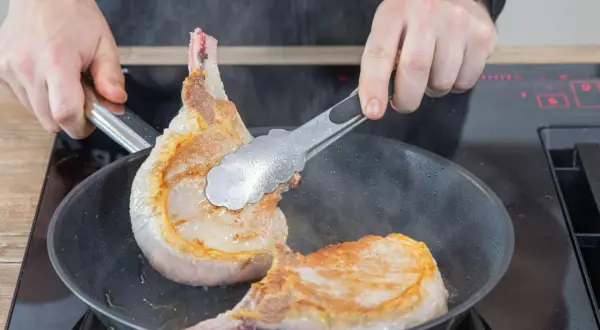 Zwei saftige Koteletts braten in der Pfanne. Ein einfaches Kotelett Rezept für den perfekten Genuss.