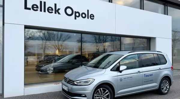 Srebrny Volkswagen Touran przed salonem Lellek Opole.