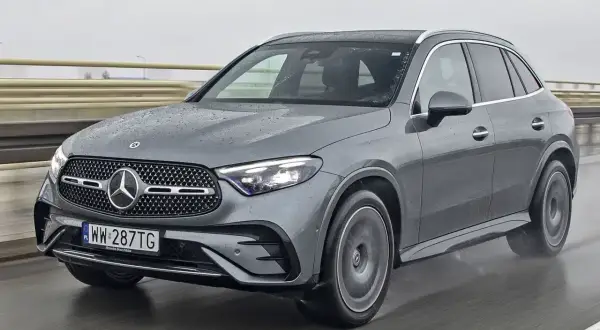 Szary Mercedes GLC 300d na mokrej drodze, z widocznymi kroplami deszczu na karoserii.