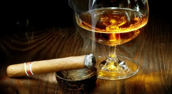 Dymiące cygaro i kieliszek bursztynowego trunku. Czy whisky podnosi cukier? To pytanie zadaje sobie wielu, delektując się tym zestawieniem.