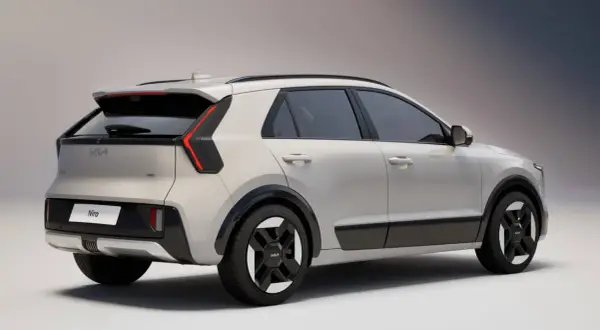 Nowy Kia Niro w kolorze jasnoszarym, widok z tyłu. Stylowe, pionowe światła tylne i czarne akcenty podkreślają nowoczesny design.