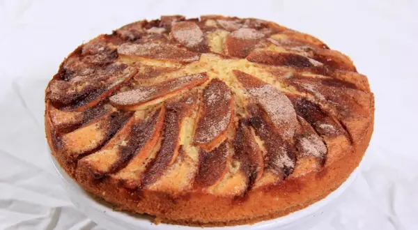 En saftig torta di mele, med äppelklyftor och kanel, redo att avnjutas.