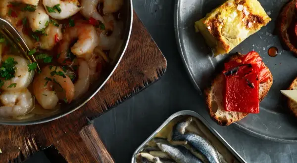 En härlig samling tapas med räkor i vitlök, sardiner och bröd med ost och paprika. Perfekt vin till tapas.