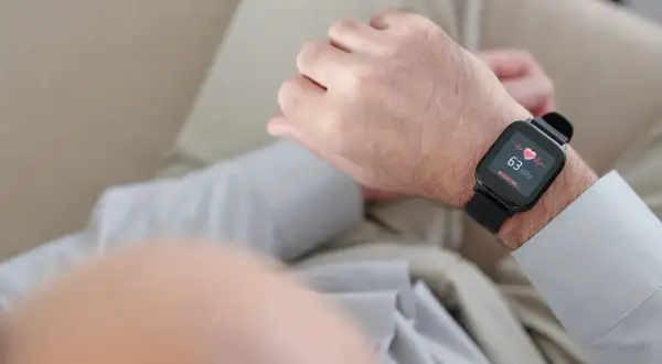 Mężczyzna sprawdza na smartwatchu swój niski puls, który wynosi 63 uderzenia na minutę.