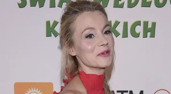 Anna Ilczuk, znana z ról filmowych, w czerwonej sukni. Jej mąż, jeśli jest obecny, pozostaje poza kadrem.