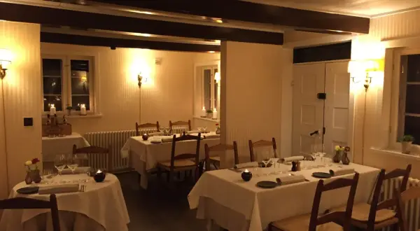 Mysig restaurangmiljö med dukade bord och levande ljus. Perfekt för en middag på en av Odenses många restauranger.