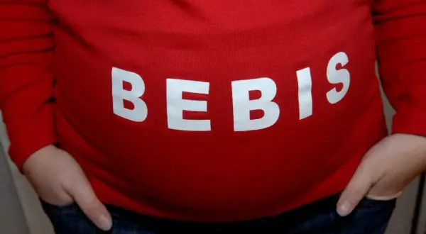 Gravid mage med texten "BEBIS". Viktigt att undvika alkohol tidig graviditet för bebisens skull.
