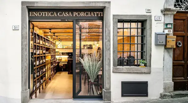 Enoteca Casa Porciatti, sklep z winami w sercu Chianti, zaprasza do degustacji. Wnętrze pełne butelek i ceglanych ścian.