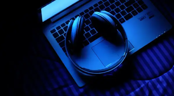 Słuchawki na laptopie w niebieskim świetle. Zastanawiasz się, ile trwa ósemka nuta?