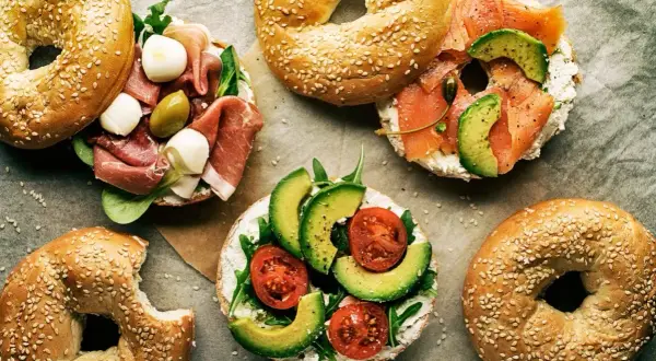Pyszne bajgle z łososiem, awokado, pomidorkami, mozzarellą i szynką. Idealne co zamiast chleba na śniadanie lub lunch.