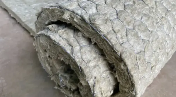 Gerolltes Dämmmaterial mit Drahtgeflecht. Um asbest erkennen zu können, ist Vorsicht geboten, da es sich um ein gesundheitsschädliches Material handelt.