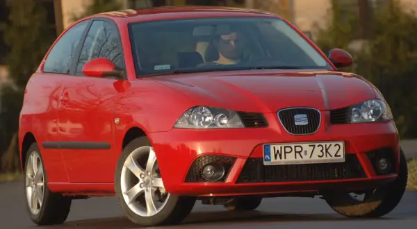 Czerwony Seat Ibiza 3, widok z przodu. Kierowca za kierownicą. Wymiary tego modelu są kompaktowe.