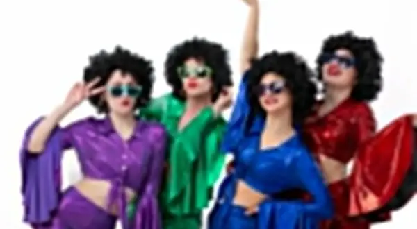 Kolorowa stylizacja na andrzejki: cztery kobiety w perukach afro i błyszczących strojach disco, z okularami przeciwsłonecznymi, tańczą i pozują.