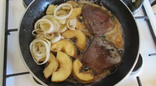 Leber braten: Zwiebelringe und Apfelspalten in der Pfanne mit der Leber garen.