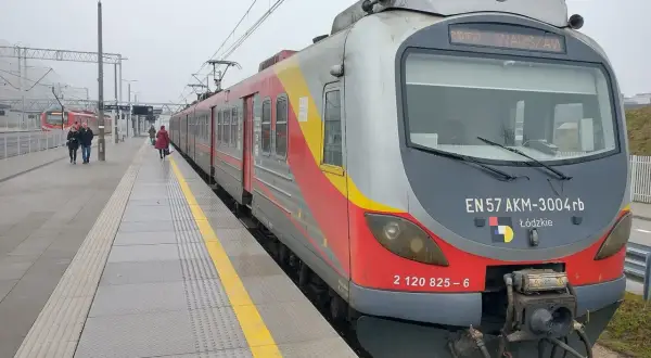 Pociąg EN57 AKM-3004rb z napisem "WARSZAWA" na stacji. Sprawdź rozkład jazdy Nowy Dwór Mazowiecki, aby zaplanować podróż.