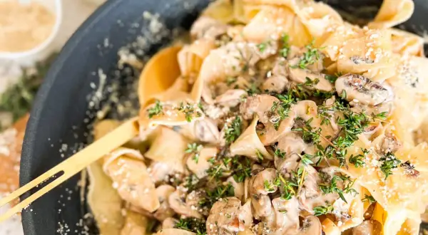Cremige Pasta mit Pilzen und frischem Thymian, garniert mit Parmesan. Ein köstliches Gericht, das Lust auf mehr macht.