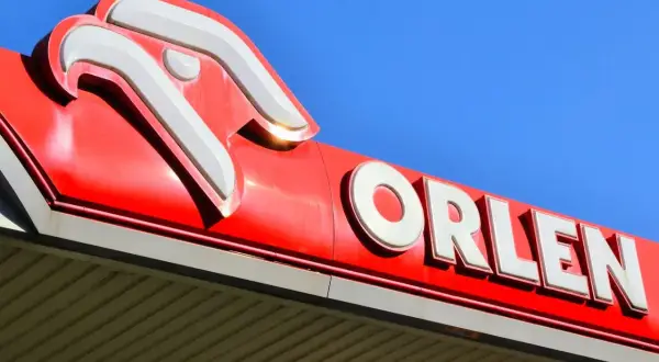 Logo Orlen na tle błękitnego nieba. Akcje PKN Orlen są symbolem polskiej gospodarki.