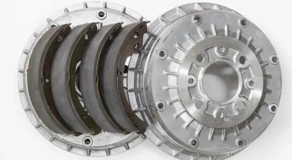 Pièces détachées d'un frein à tambour : mâchoires neuves et tambour en aluminium.