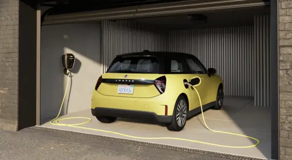 Żółty elektryczny Cooper w garażu, podłączony do ładowarki. Idealny wybór dla leasingu konsumenckiego samochodu.