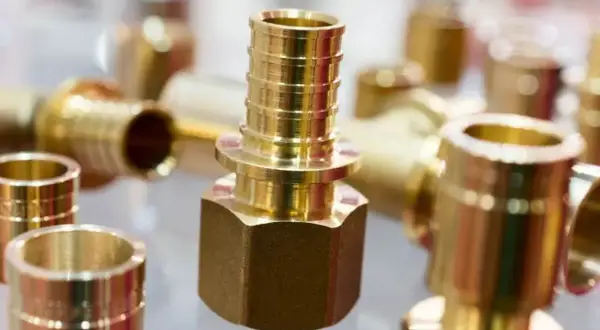 Zastosowanie mosiądzu w instalacjach hydraulicznych: błyszczące złączki i kształtki, gotowe do montażu.