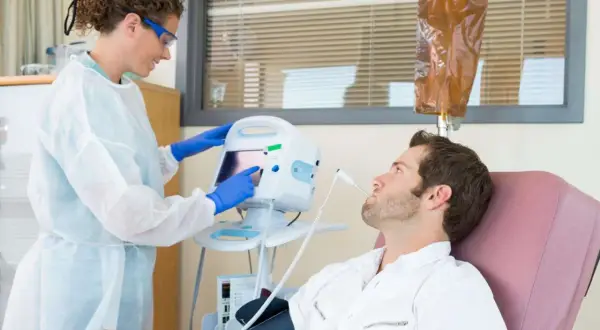 Eine Krankenschwester überwacht die Vitalwerte eines Patienten während einer Chemotherapie. Die Frage, welche Chemo am schlimmsten ist, beschäftigt viele.