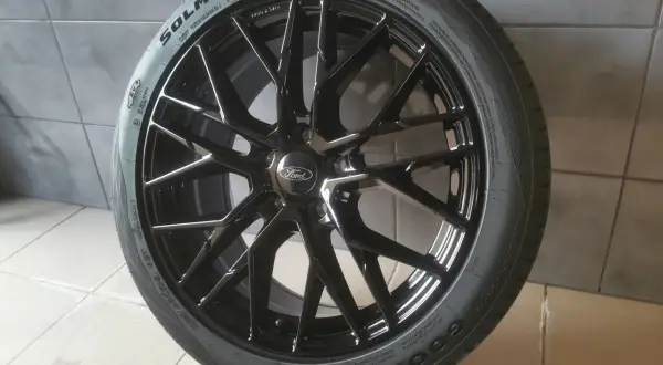 Czarna felga Ford Vignale z oponą Goodride na szarym tle.