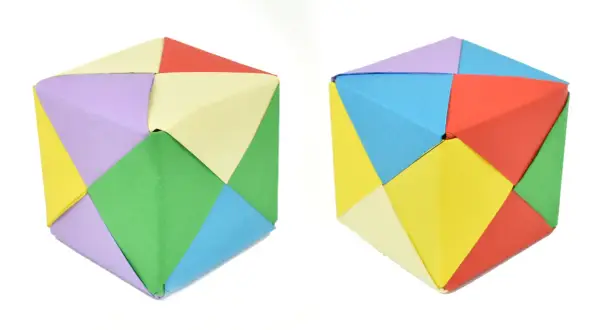 Dos cubos de papel para imprimir, hechos de módulos de colores: verde, amarillo, lila, azul, rojo y crema.