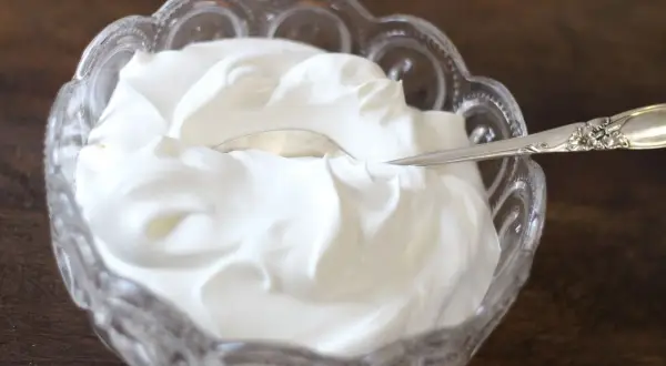 Gęsta, biała śmietana w kryształowej miseczce. Czy to creme fraiche? Tak, to właśnie creme fraiche, idealna do deserów i sosów.