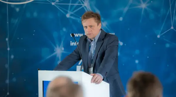 Mężczyzna w garniturze przemawia na konferencji. Dowiadujemy się, ctf co to jest, dzięki jego prezentacji.