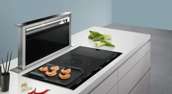 Nowoczesna kuchnia z wysuwaną wentylacją okapu, płytą indukcyjną z grillem i krewetkami.