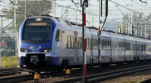 Niebieski pociąg PKP Intercity ED160-007a, kursujący na trasie Zamość - Kraków, zbliża się do stacji.