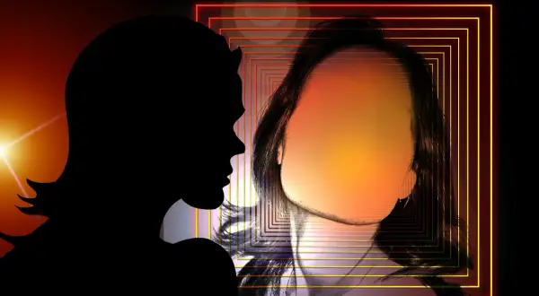 Sylwetka osoby patrzy na odbicie w lustrze z geometrycznymi ramkami i rozmyciem.