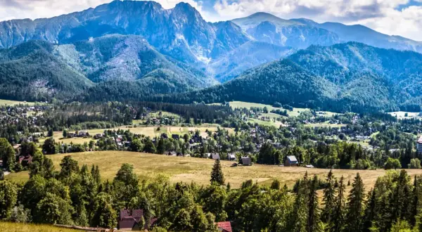 Widok na Zakopane z górami w tle. Warto sprawdzić ceny noclegów i atrakcji, by zaplanować udany pobyt.