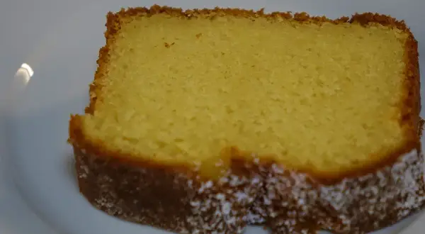 Ein saftiges Stück Kuchen mit Dinkelmehl und Quark, leicht mit Puderzucker bestäubt.