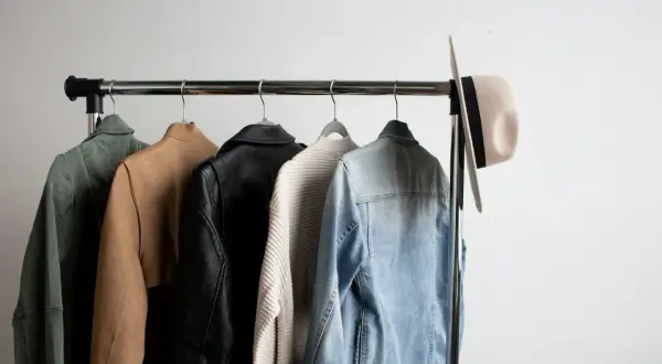 Jacken und ein Hut auf einer Kleiderstange, perfekt für einen casual chic sommer Look.