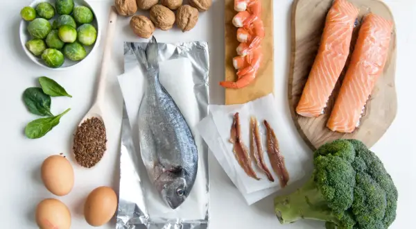 Różnorodne produkty bogate w omega 3: łosoś, sardele, krewetki, ryba morska, orzechy, siemię lniane, brokuły, brukselka, szpinak i jajka.