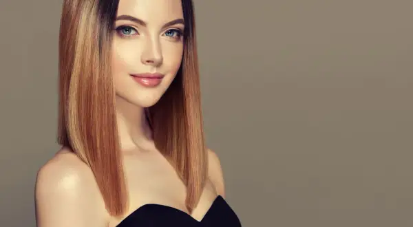 Kobieta z pięknymi, prostymi fryzurami do ramion w odcieniach blondu i brązu.