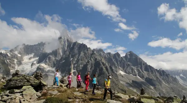 Groupe de randonneurs profitant d'une magnifique randonnée à Chamonix, avec des montagnes imposantes en arrière-plan.