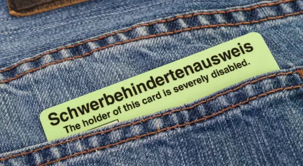 Schwerbehindertenausweis in Jeans-Tasche. Der Ausweis bestätigt den Grad der Behinderung, z.B. bei Herzschrittmacher-Trägern.